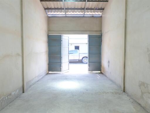 Spacious garage with open double doors and a pickup truck outside