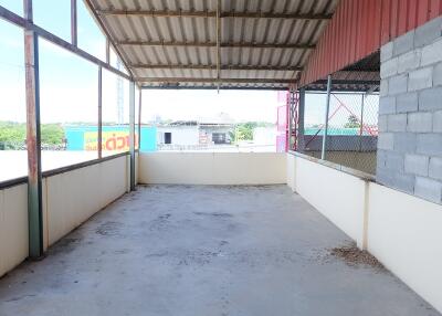 Spacious covered balcony with corrugated metal roof