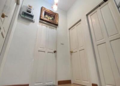 Well-lit hallway with wooden flooring and white doors