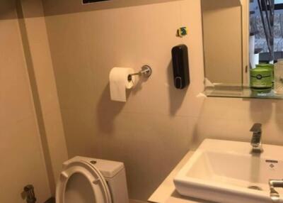 Modern bathroom with toilet, sink, and mirror