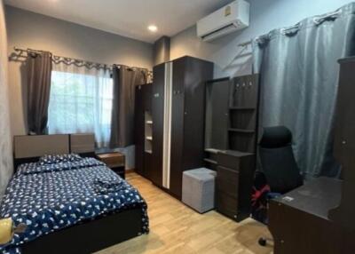 Modern bedroom with bed, wardrobe, desk, and ample storage space.