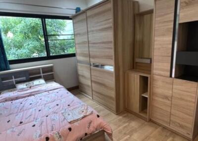 Cozy bedroom with wooden furniture and large window