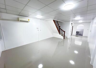 Spacious main living area with stairs and adjoining kitchen