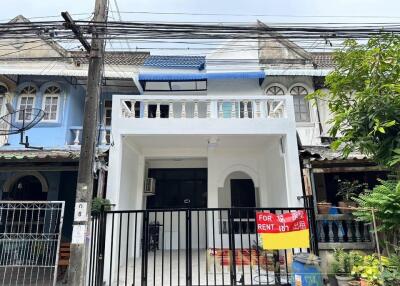 Exterior view of a white two-story house with a balcony