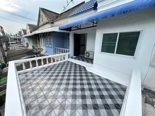 Front view of a building with a tiled terrace