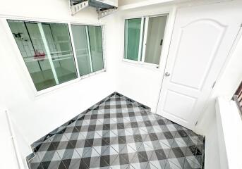 Enclosed balcony with tiled floor and large windows