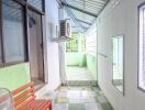 Outdoor hallway with bench and air conditioner