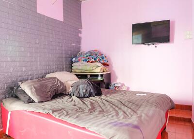 Bedroom with bed, blankets, and wall-mounted TV