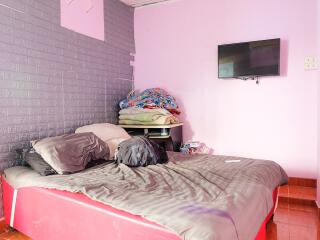 Bedroom with bed, blankets, and wall-mounted TV