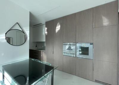 Modern kitchen with built-in appliances and glass dining table