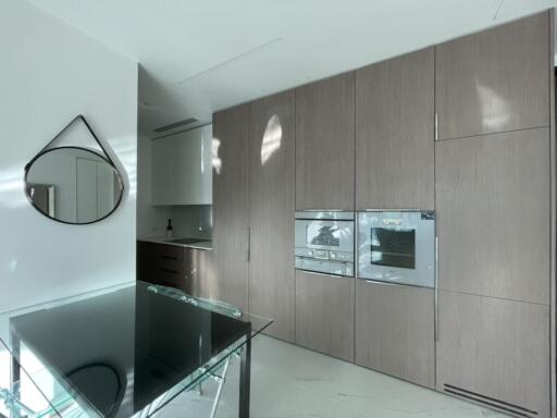 Modern kitchen with built-in appliances and glass dining table