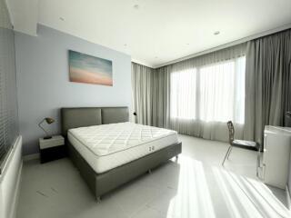 Bright modern bedroom with large window, bed, and desk