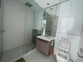 Modern bathroom with glass-enclosed shower and white fixtures