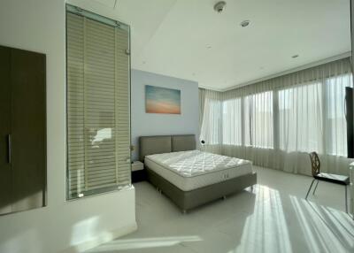 Modern bedroom with large windows and natural lighting