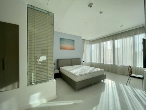 Modern bedroom with large windows and natural lighting