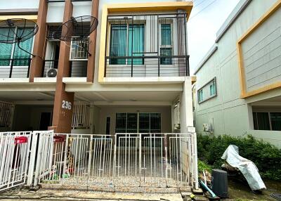 Front view of a multi-story residential building with a fenced yard