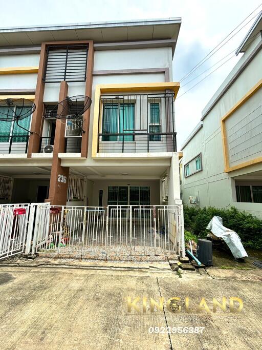 Front view of a multi-story residential building with a fenced yard