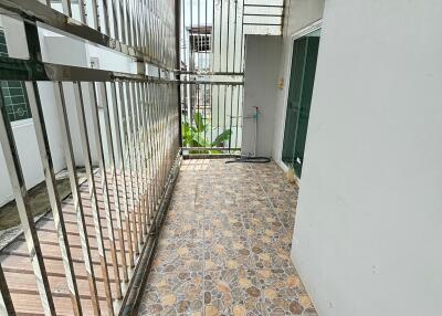 Narrow balcony with tiled floor and metal railing