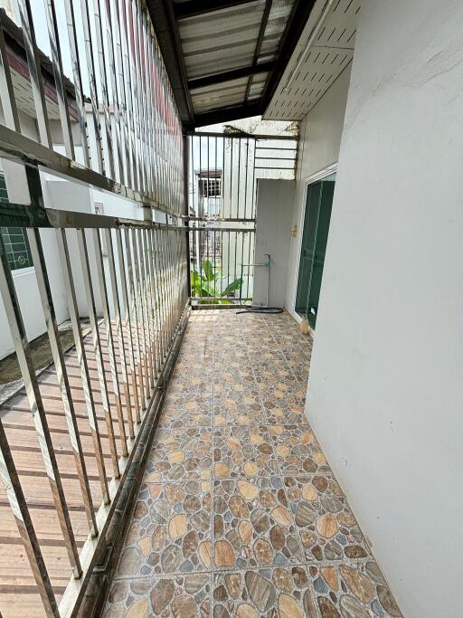 Narrow balcony with tiled floor and metal railing