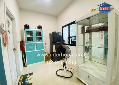 Office room with cabinets, a fan, and a display case