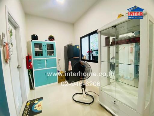 Office room with cabinets, a fan, and a display case