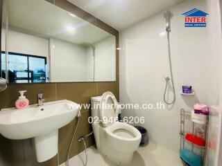 Modern bathroom with sink, toilet, and shower.