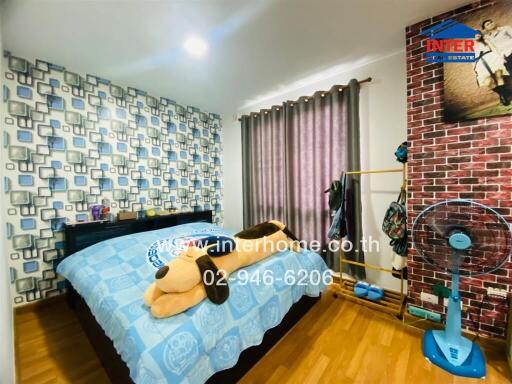 Well-lit bedroom with stylish wall and cozy bedding