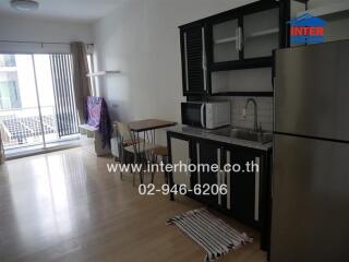 Modern kitchen area with black cabinets, stainless steel appliances, and adjacent dining space