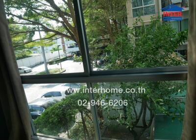 View from balcony overlooking parking lot and surrounding greenery