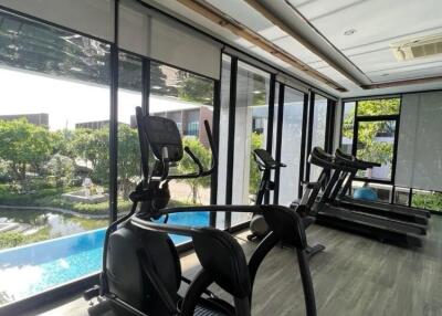 Home gym with a view of a pool and garden