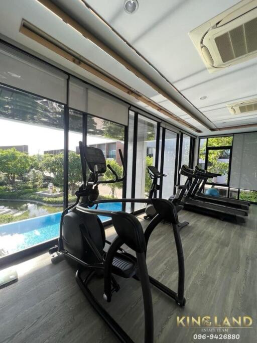 Home gym with a view of a pool and garden