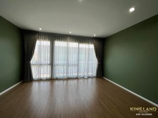 Spacious living room with large windows and wooden floor