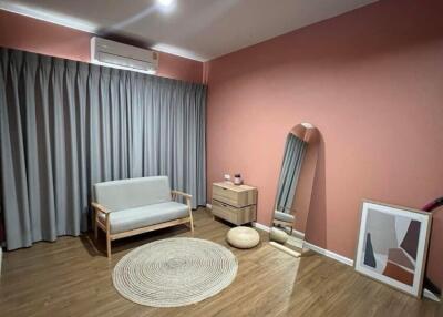 Cozy bedroom with pink walls and wooden flooring