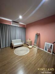 Cozy bedroom with pink walls and wooden flooring