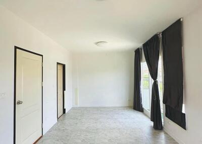 Spacious living room with tiled flooring and large windows