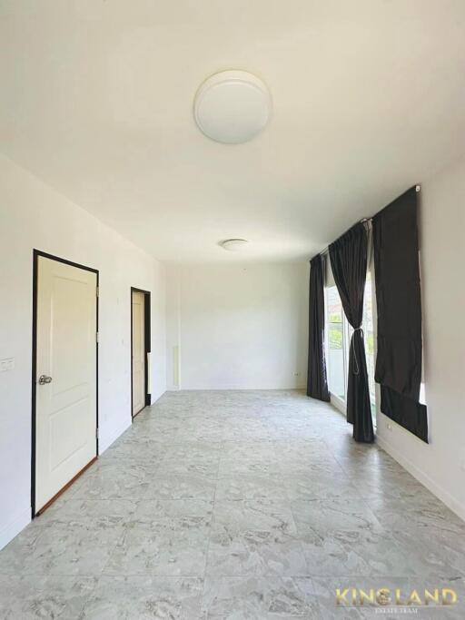 Spacious living room with tiled flooring and large windows