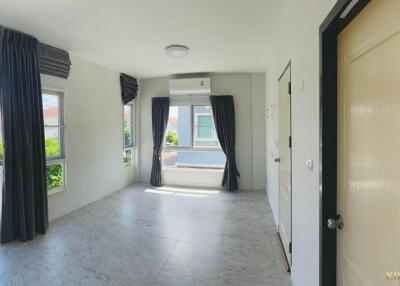 Empty bedroom with large windows and gray curtains