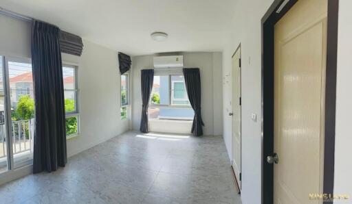 Empty bedroom with large windows and gray curtains