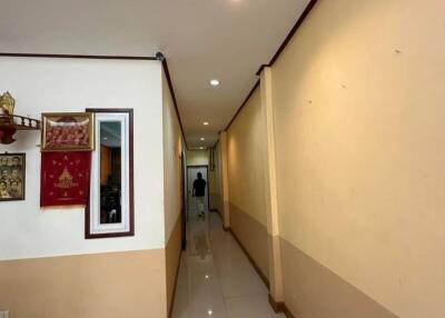 Interior hallway with light yellow walls, ceiling lighting, and framed artwork