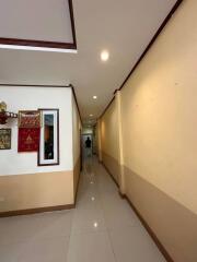 Interior hallway with light yellow walls, ceiling lighting, and framed artwork