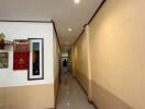 Interior hallway with light yellow walls, ceiling lighting, and framed artwork