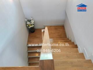 Wooden staircase with wall-mounted handrail