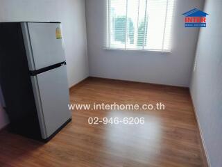 Empty kitchen with refrigerator and window