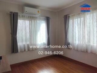 Bedroom with windows, air conditioner, and curtains