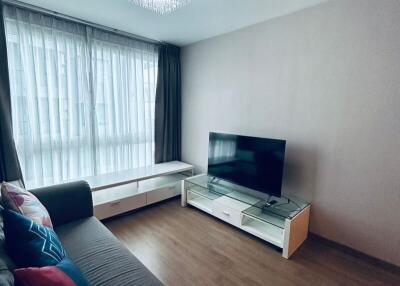 Living room with a television, couch, and large window