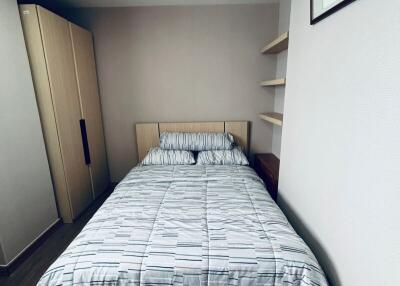 Cozy bedroom with double bed, wardrobe, and shelves