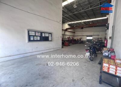 Spacious industrial warehouse with some equipment and parking