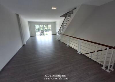 Spacious living area with large windows and modern staircase