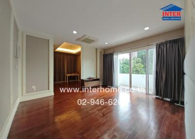 Spacious living room with hardwood floors and large windows