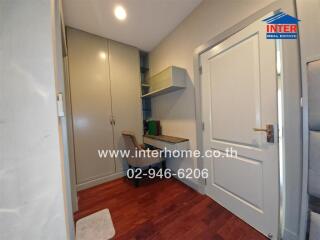 Home office with built-in desk and chair next to a large storage cabinet